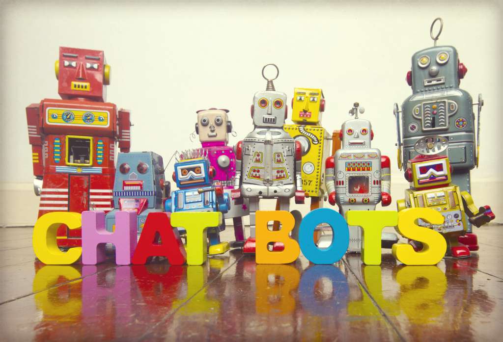 Picture of vintage toy robots with wooden blocks spelling out the word chatbots